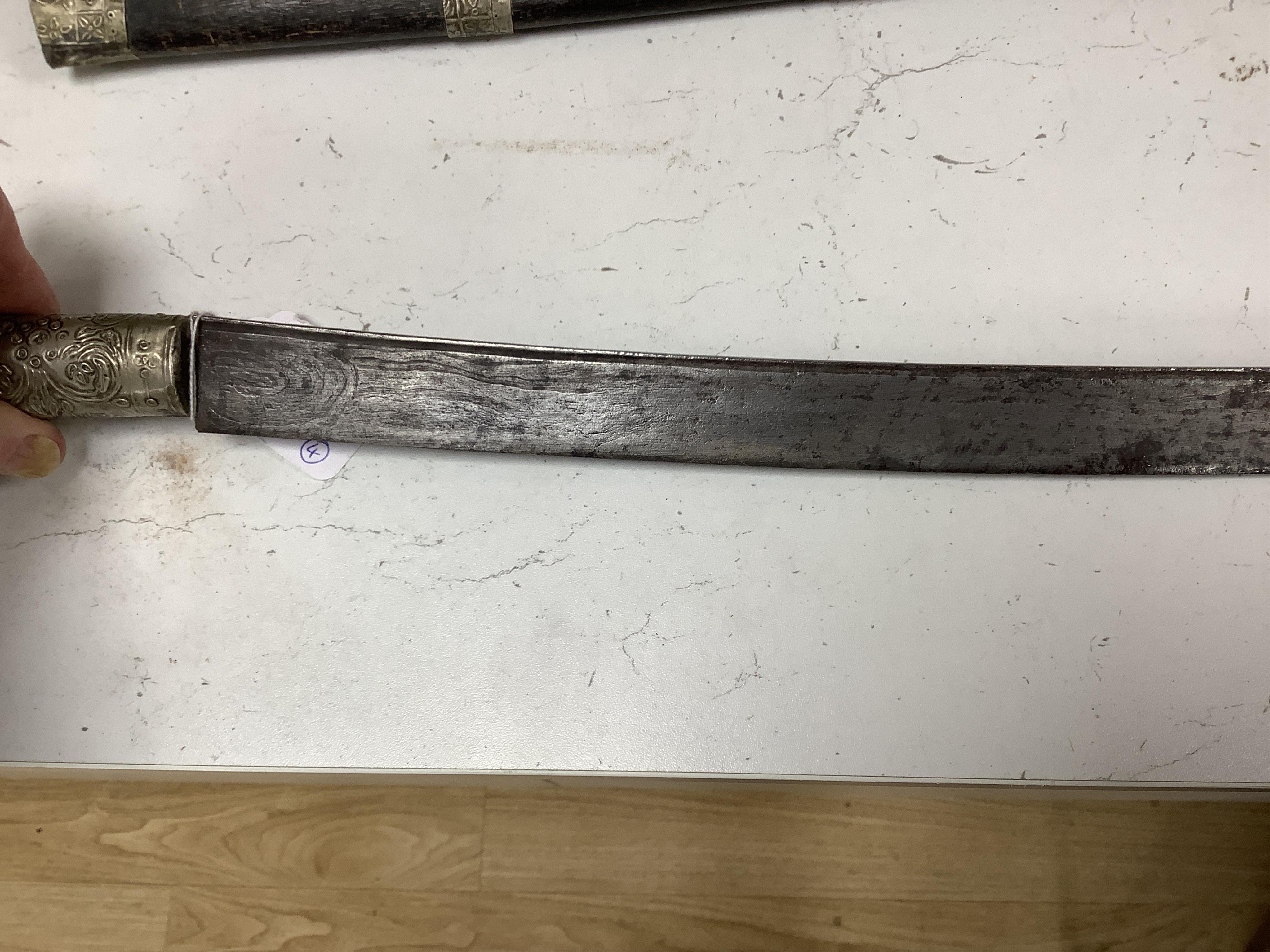 Four bladed weapons; an Indian sword Tulwar, blade 68.5cm. Condition - poor, heavily pitted., A Nepalese Kukri. Condition - fair., A Thai sword Dha, with a lacquered hilt and wooden scabbard, blade 56cm. Condition - fair